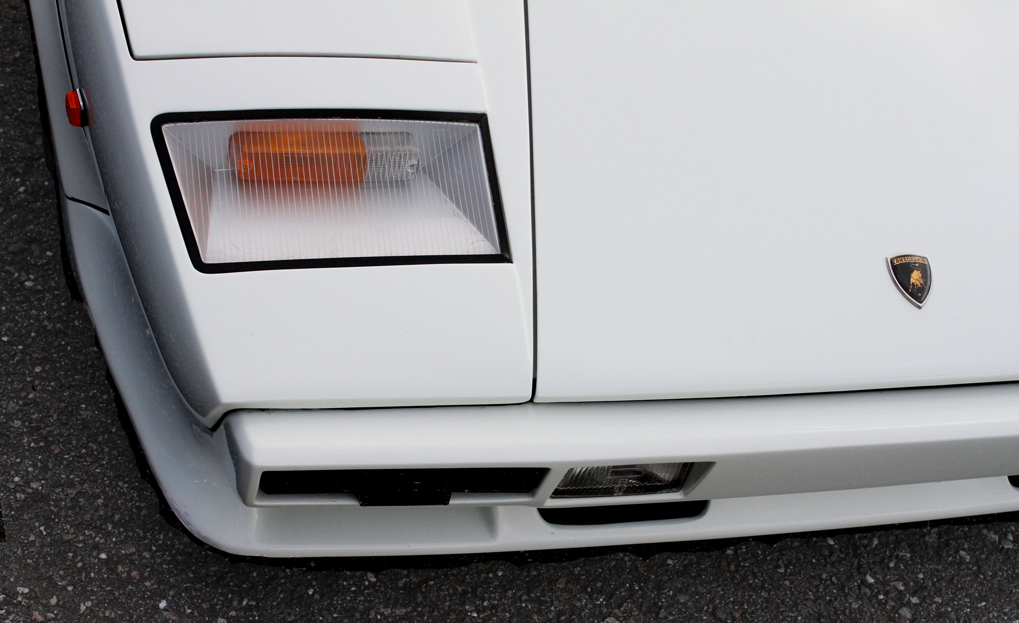 Vit Lamborghini Countach höger framlampa med Lambo emblemet på bagage luckan
