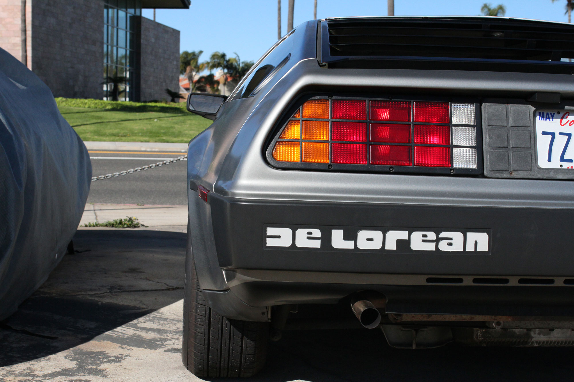 The rear of the AMC DeLorean - 1981 beside Highway One