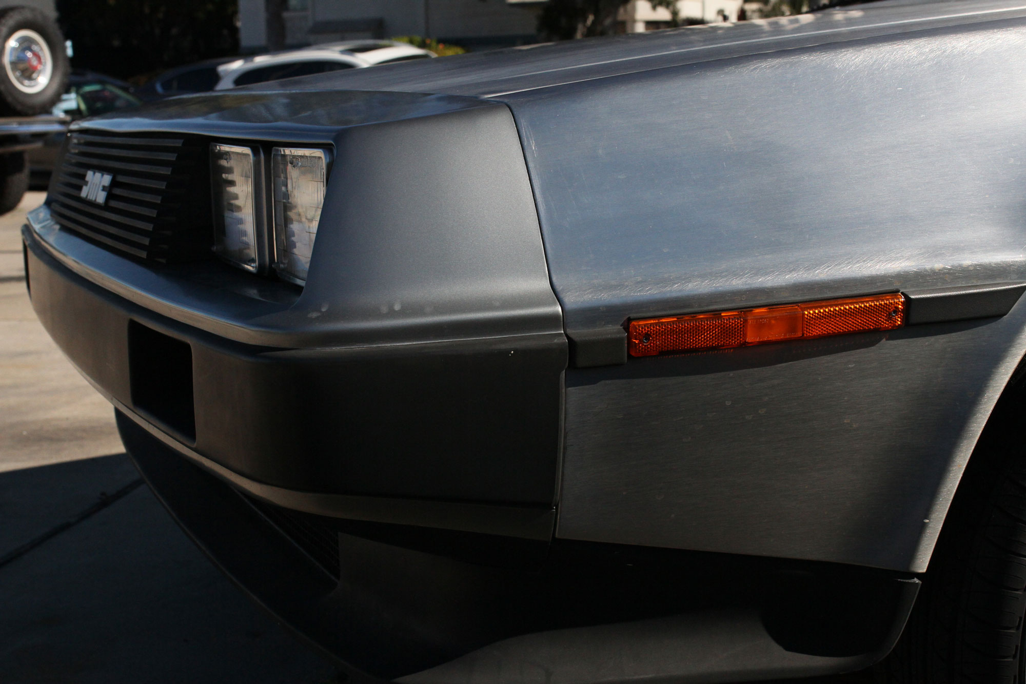 vänster front av DeLorean 1981 utanför Garage 77 med Ford Bronco i bakgrunden