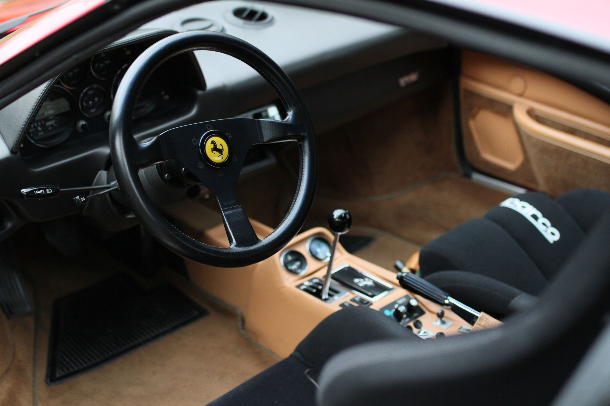 The black steering wheel and the beige interior of the Ferrari 308 GTB QV - 1984