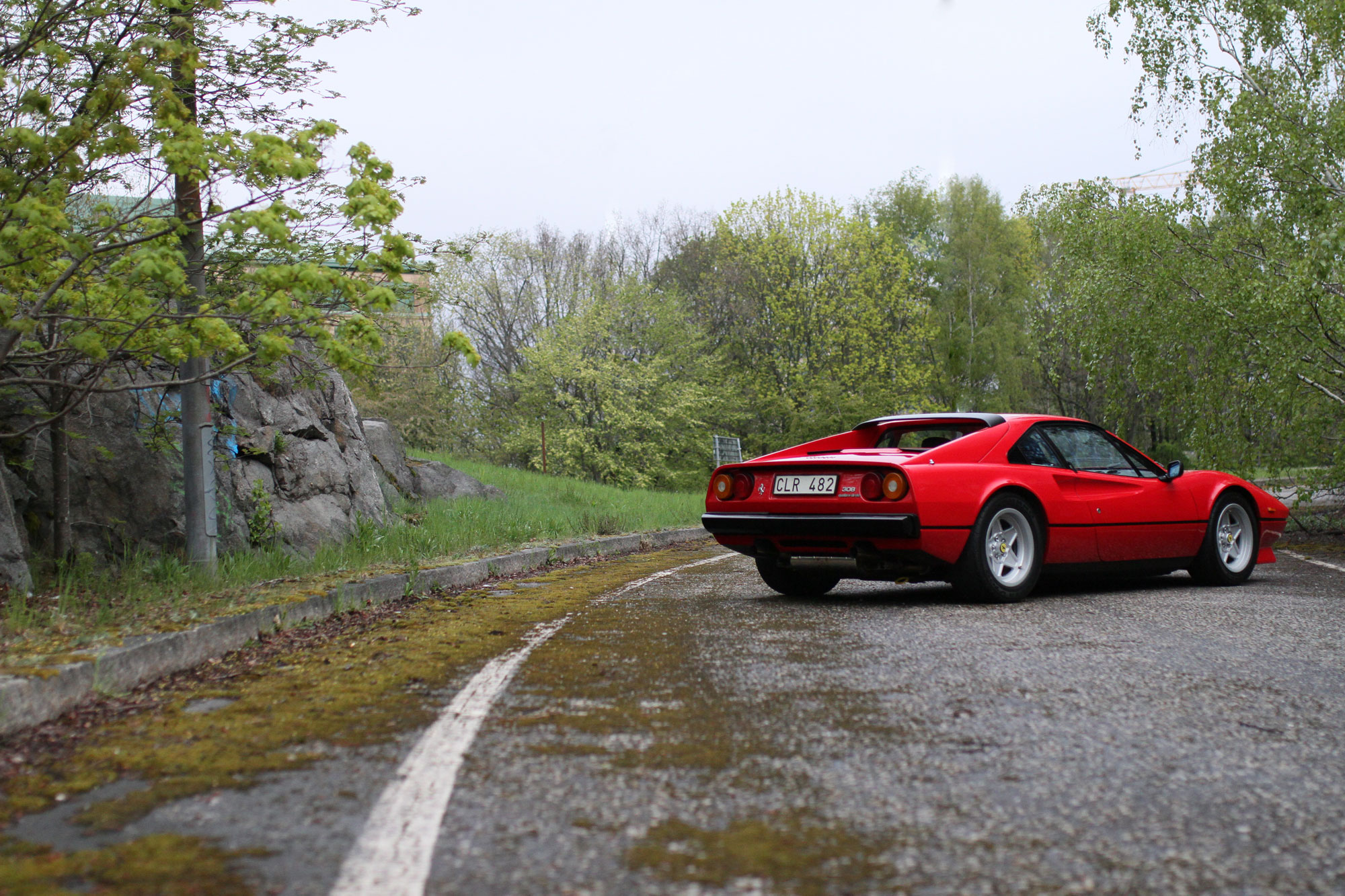 The Ferrari 308 GTB QV - 1984 from behind on a deserted Highway exit